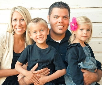 Jeremy James Osmond in a black shirt with his wife in white outer and his children in t-shirts and pants.